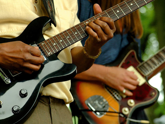 two people playing guitar